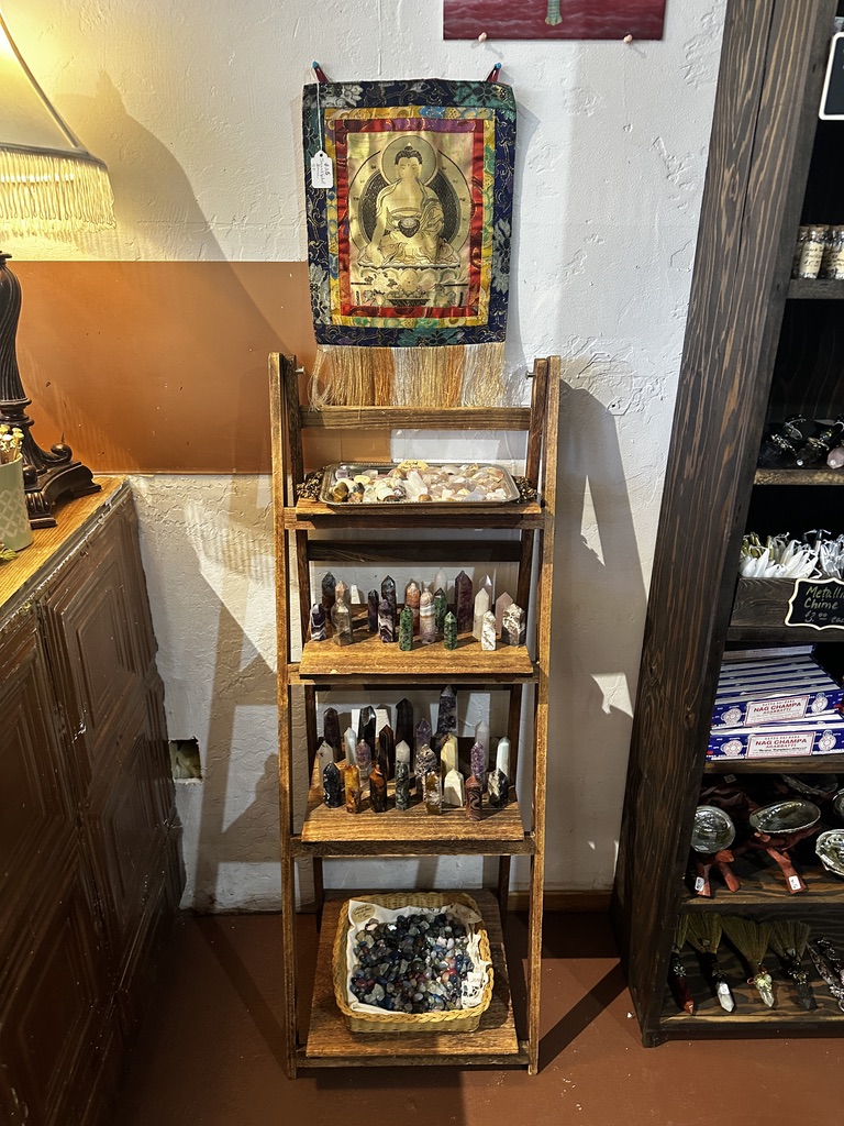 A wooden ladder shelf of polished crystal points and tumbled stones
