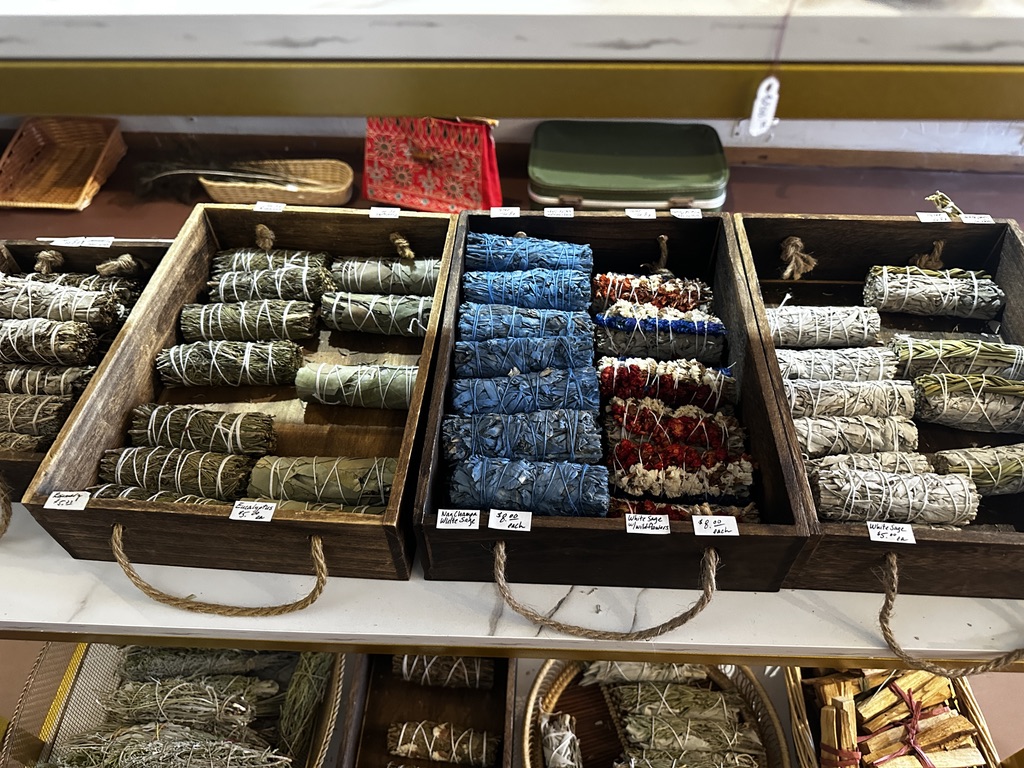 Wooden boxes of bundled sage, rosemary, eucalyptus, and palo santo