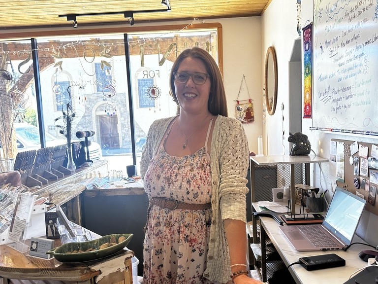 Layne, owner of Hint of Sage, smiling in the shop